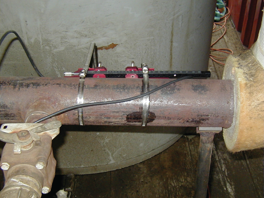 A photographic image of ultrasonic flow meter installed too close to pipe fittings.