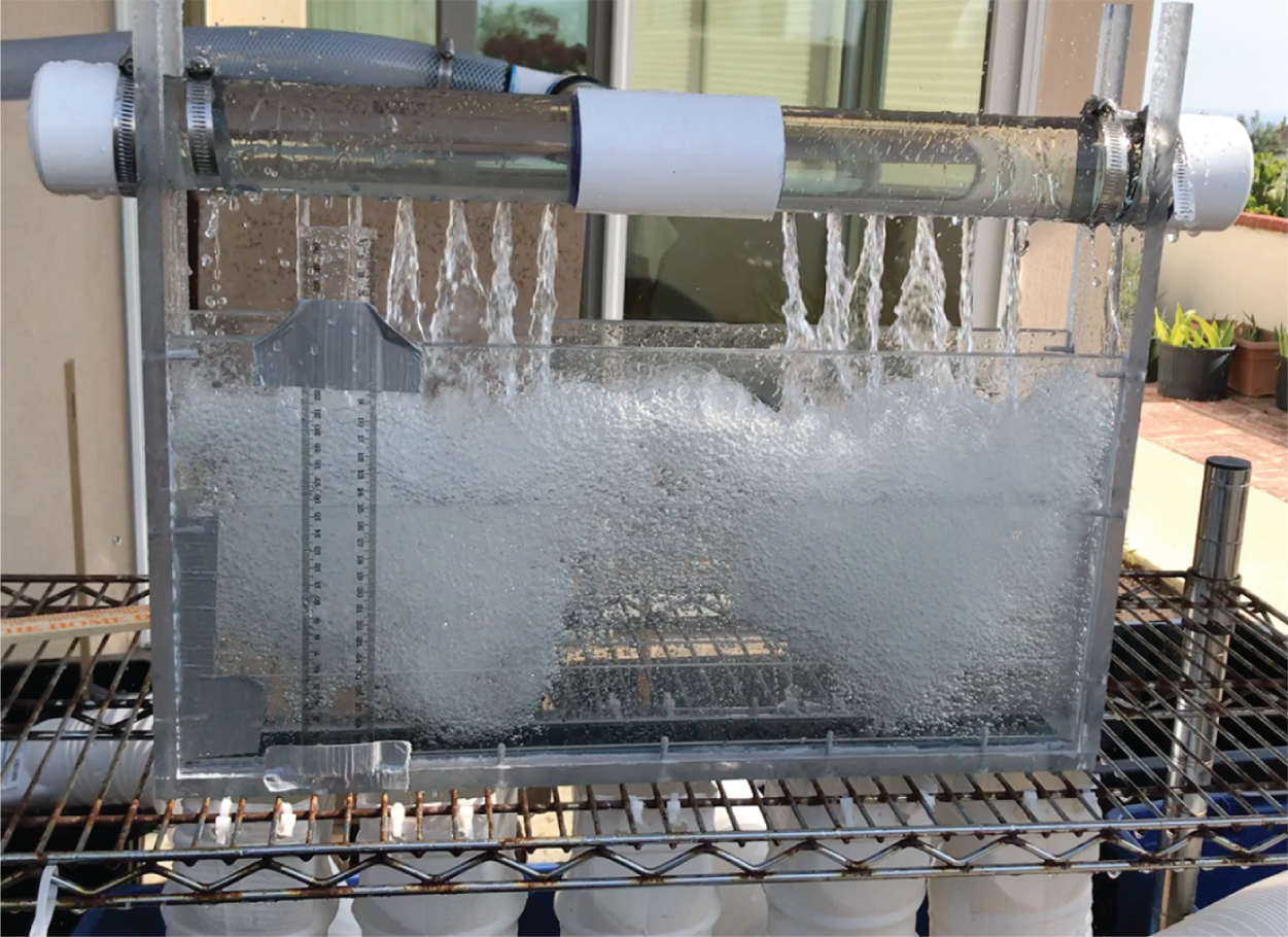 A photograph of a water tests with the sparger-fed model parting box with the froth heights are taller than the liquid heads and calculated using the orifice.
