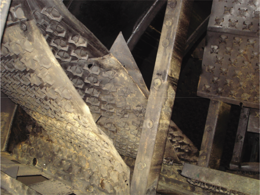 A photograph of severely damaged trays above the feed of a crude fractionator.