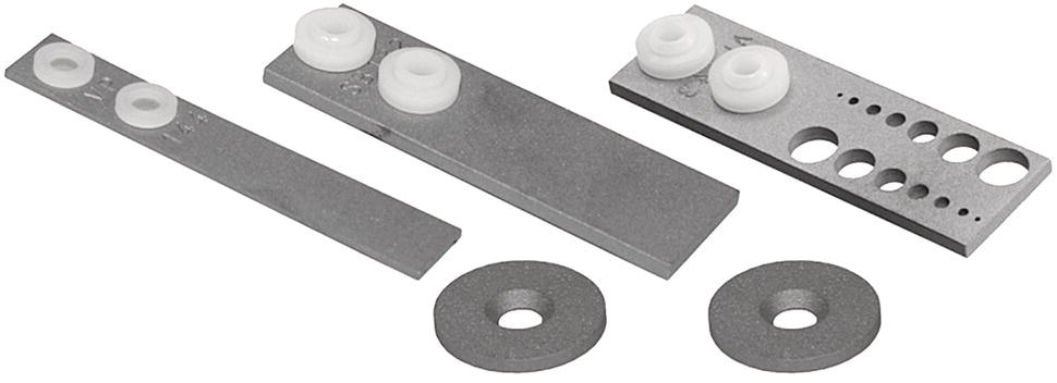 An image features various metallic components arranged on a light background. There are three elongated metal strips, two with circular plastic discs attached. The longest strip has multiple holes along its length, while one shorter strip has two discs positioned near one end. Additionally, two round metallic washers are present, displaying a smooth surface and a central hole. The overall composition emphasizes the different shapes and arrangements of these hardware elements, suggesting their use in mechanical or engineering applications.