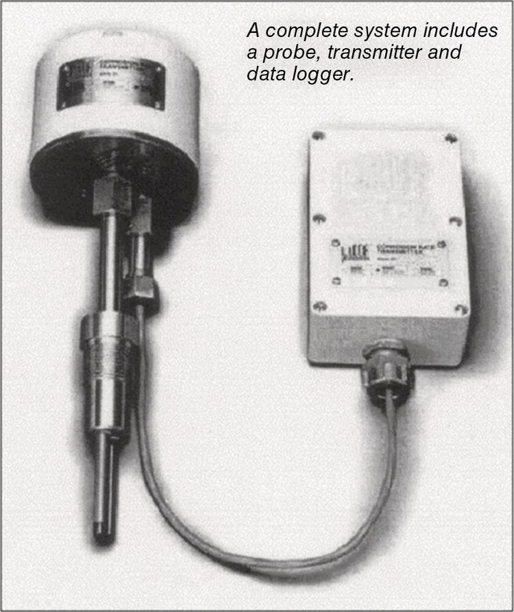A measurement system consists of a cylindrical probe and a rectangular data logging unit connected by a coiled cable. The probe features a circular sensor at the top, incorporating labelled components for identification. The data logger, designed with a sturdy exterior, has a labelled surface and a connector on the side for interfacing with the probe. The arrangement emphasizes the integration of these devices for efficient data collection, crucial in various technical and scientific applications where precise measurement is required.