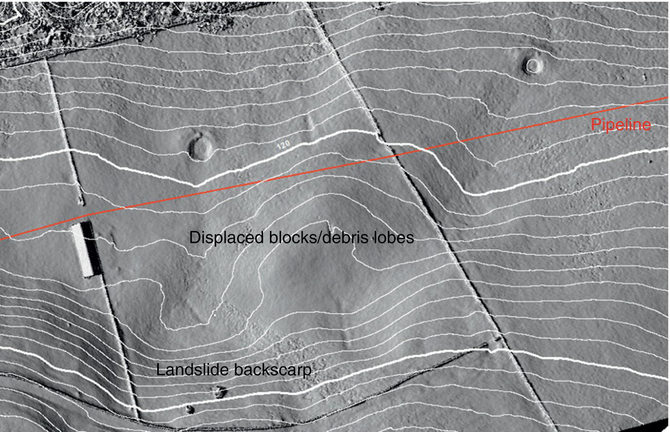 A map features various elements related to geological and infrastructural analysis. A designated pipeline runs through the area, highlighting areas of interest. Displaced blocks and debris lobes indicate sections where materials have shifted from their original positions, suggesting movement or disturbance in the surroundings. The landslide backscarp is marked, reflecting a transition zone between stable ground and the slide area. Details are organized with text annotations for clarity, accompanied by a screenshot format that enhances visual understanding while maintaining a professional appeal.