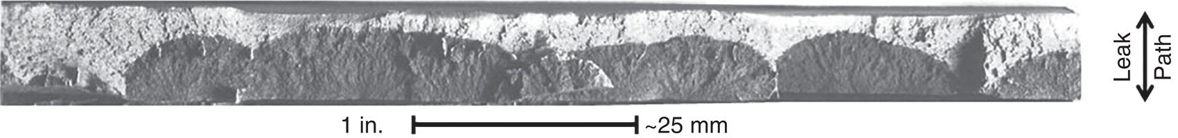 A microscopic image showing overlapped crack segments on a typical stress corrosion cracking fracture surface, highlighting crack morphology and propagation features.