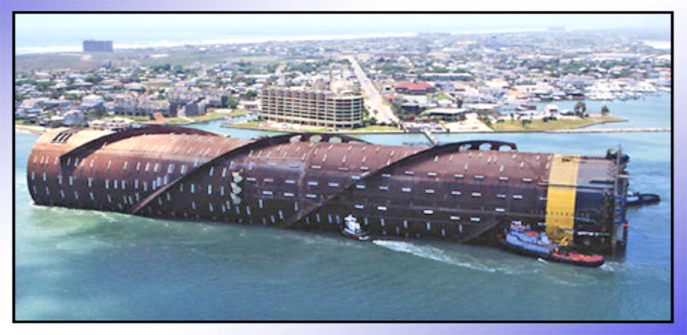A large, curving structure in the water, resembling a modern ship. In the background, a coastal city with buildings is visible.