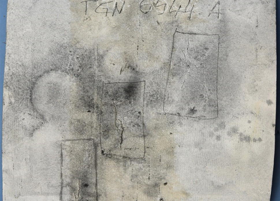 A textured image featuring circular and rectangular shapes, with some areas showing darker markings. The top includes handwritten text that reads PGN 01744 A.